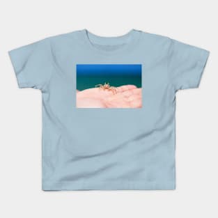 Little crab on human hand against blue sky and green ocean Kids T-Shirt
